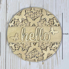 Round wooden decorative piece with butterfly patterns and 'hello' text on a light wooden background