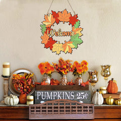 Decorative autumn wreath with 'Welcome' text, pumpkins, and floral arrangements on a table.