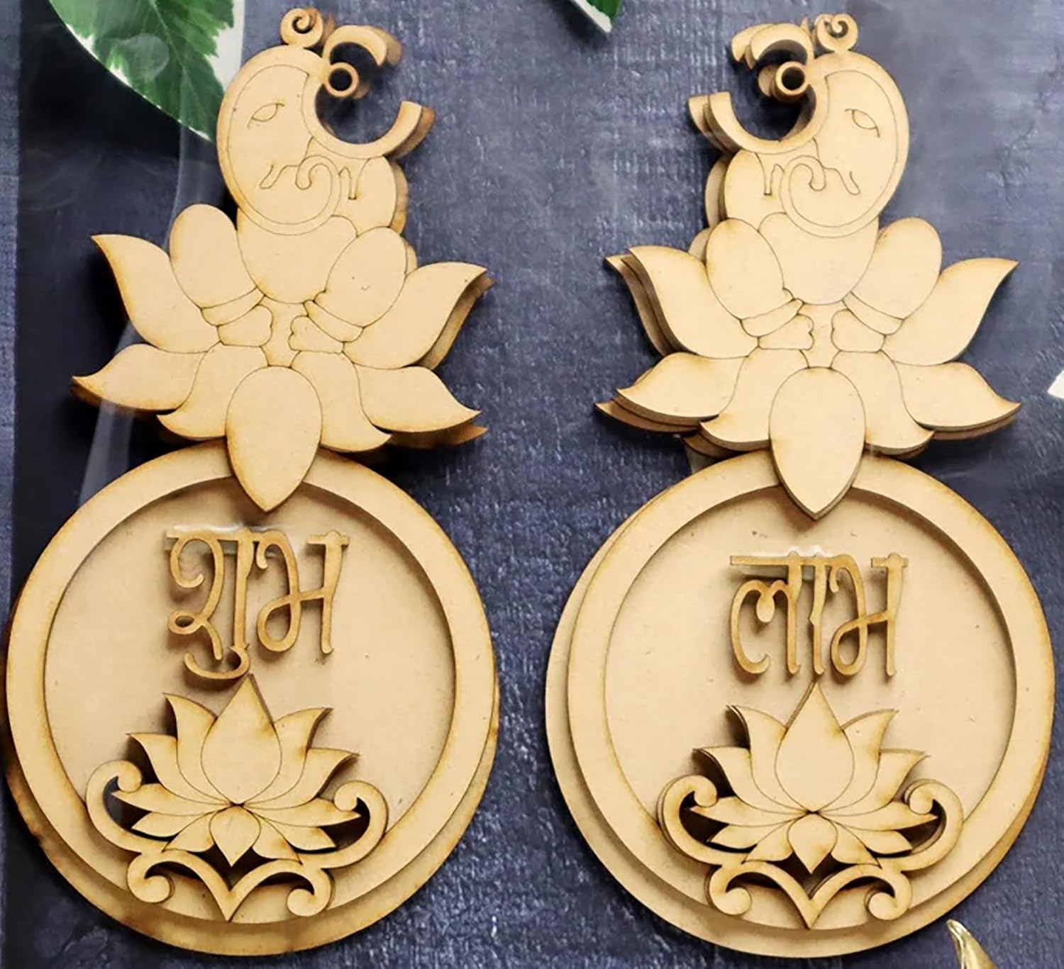 Decorative wooden ornaments with lotus designs and text on a dark background