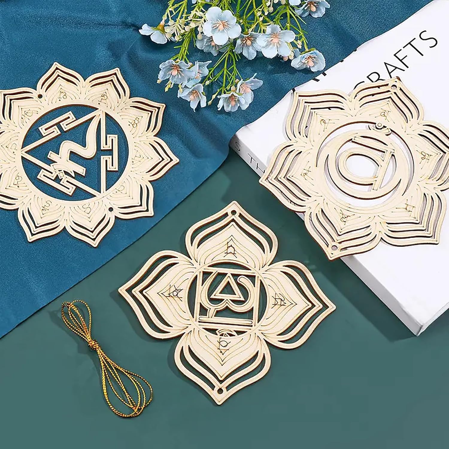 Decorative wooden cutouts with intricate designs on a blue and green surface with flowers.