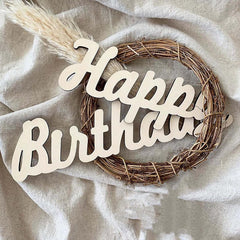 Wreath with 'Happy Birthday' text on a light fabric background