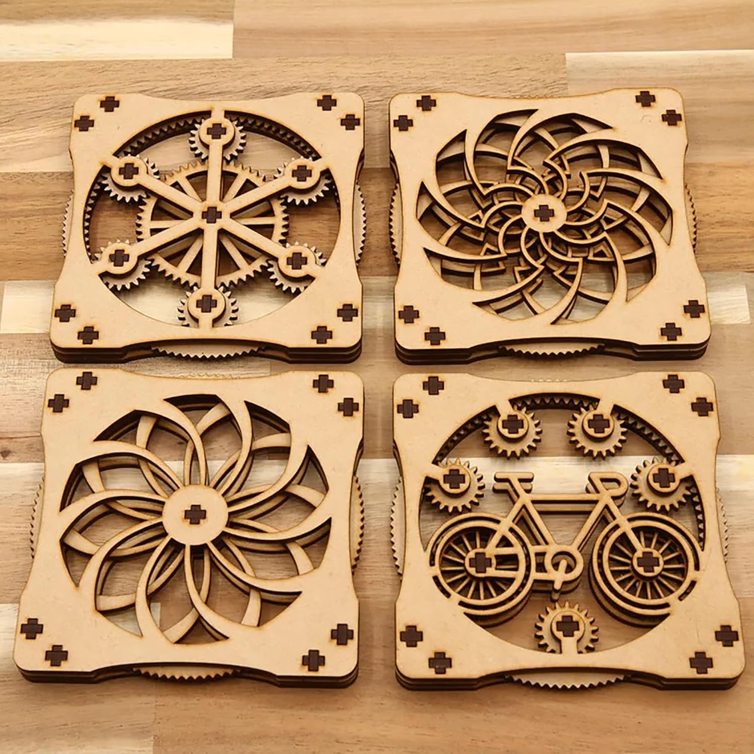 Four wooden coasters with intricate cut-out designs on a wooden surface