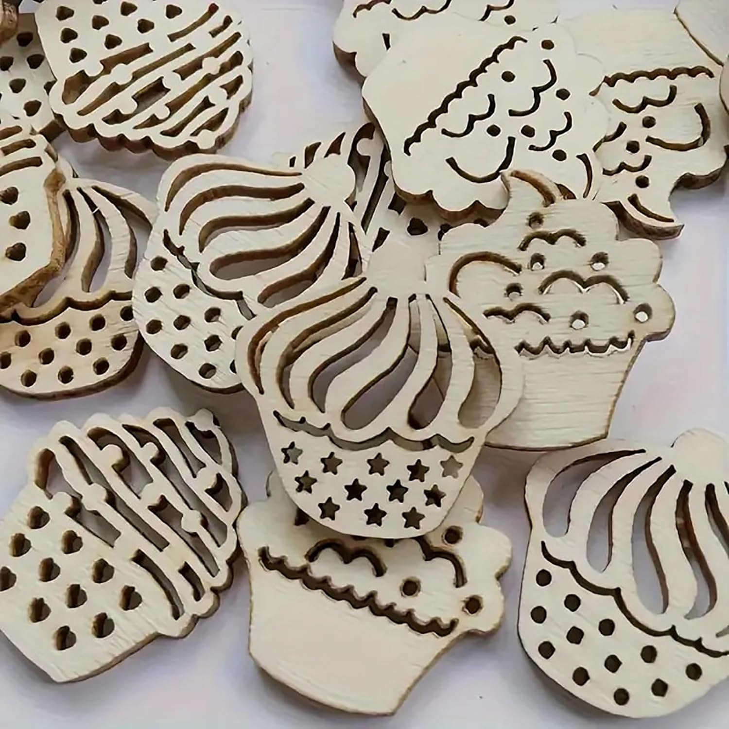 Wooden cupcake-shaped cutouts with intricate designs on a white background
