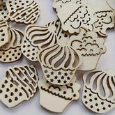 Wooden cupcake-shaped cutouts with intricate designs on a white background