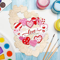 Colorful heart-shaped paper cutouts with 'love' text on a blue surface with art supplies.