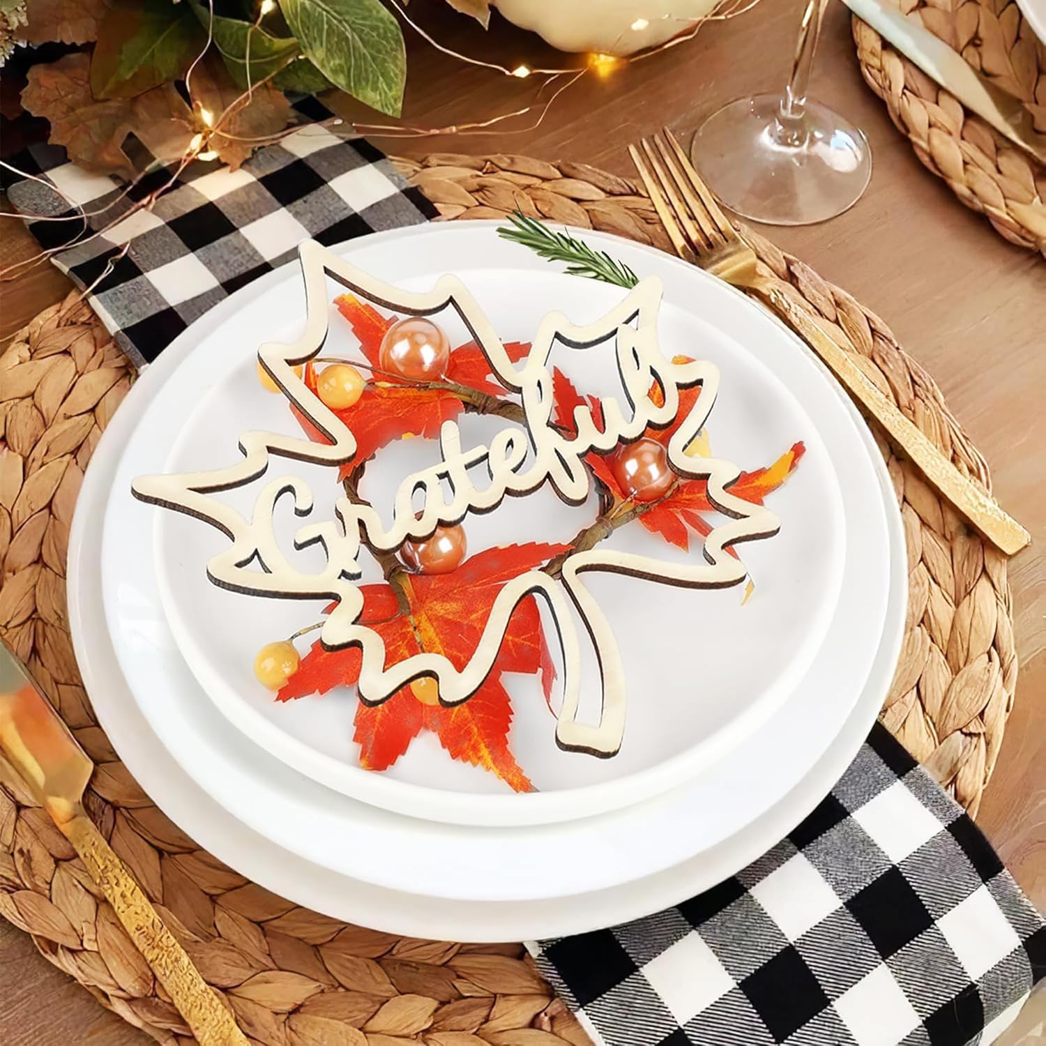 Decorative plate with 'Thankful' sign on a table setting with checkered napkin and wine glass.