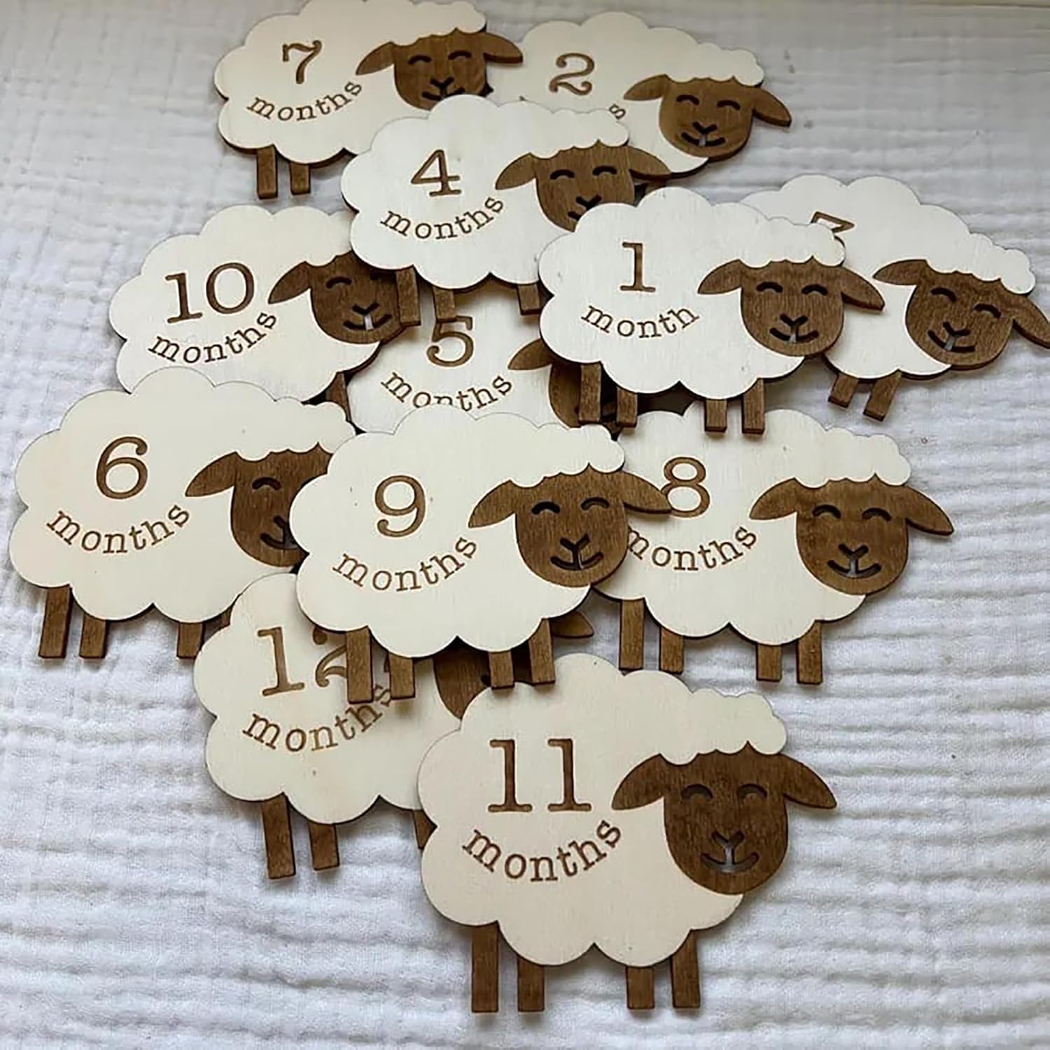 Sheep-shaped milestone markers with month labels on a textured surface