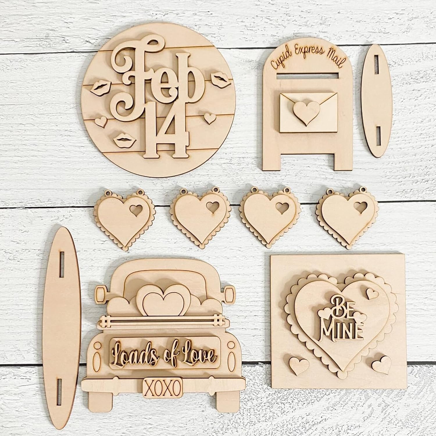 Collection of wooden Valentine's Day decorations on a light wooden background