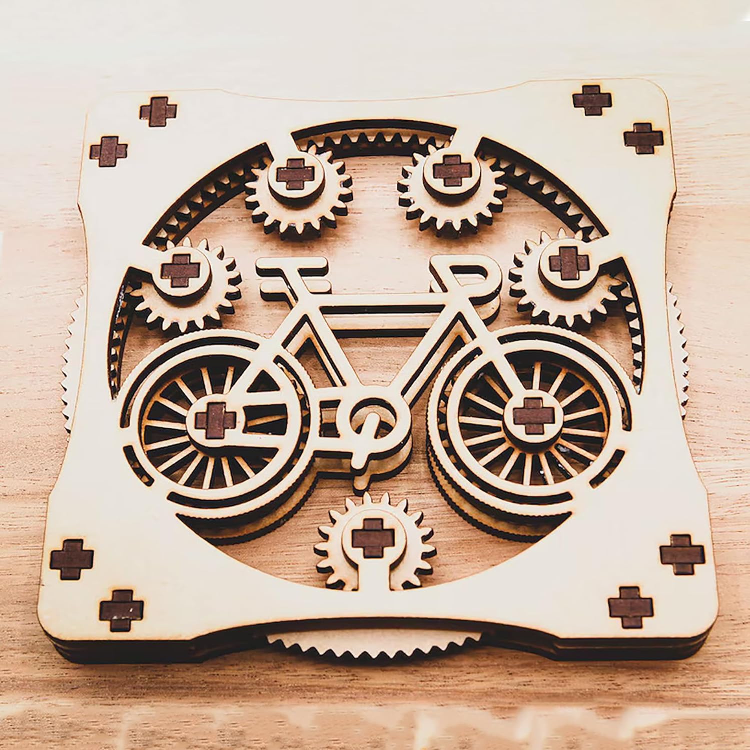 Wooden laser-cut design of a bicycle with gears on a wooden surface