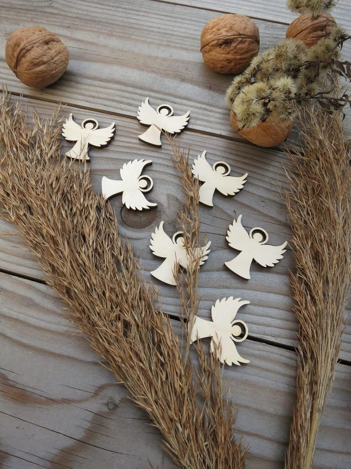 Wooden angel and dove ornaments on a wooden surface with natural elements.