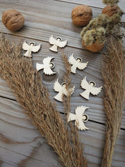 Wooden angel and dove ornaments on a wooden surface with natural elements.