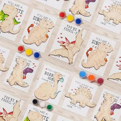 Dinosaur-themed cards with wooden cutouts and colorful dots on a white background
