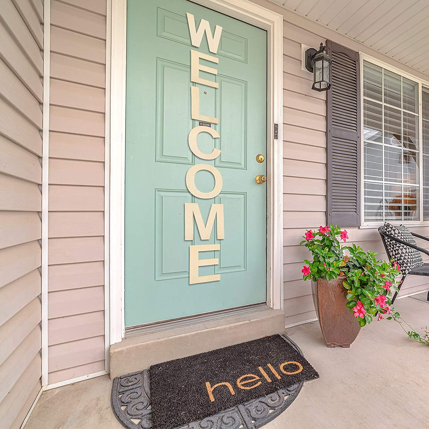 Front door with 'WELCOME' sign, doormat, and potted plant on a porch.