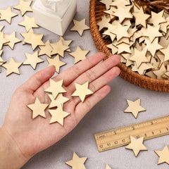 Hand holding wooden stars with a basket and ruler on a gray surface