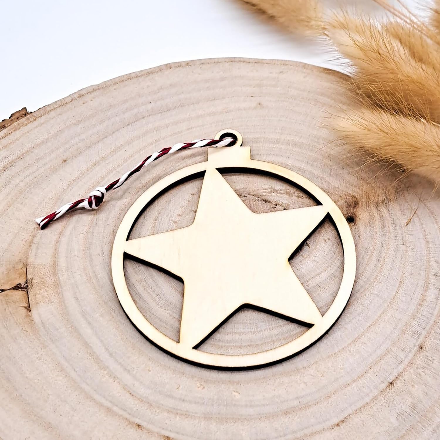 Wooden star ornament on a wooden surface with feathers in the background