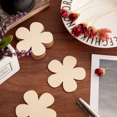 Flower-shaped wooden coasters on a wooden surface with decorative elements.