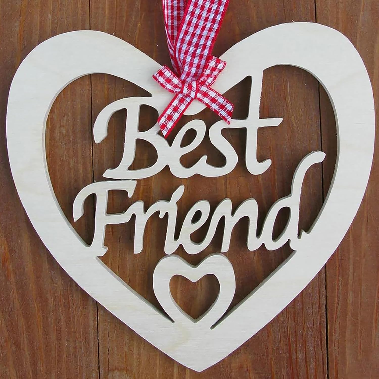 Heart-shaped wooden sign with 'Best Friend' text and a red and white checkered ribbon on a wooden background.