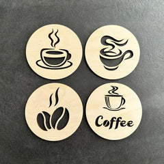 Four wooden coasters with coffee-themed designs on a dark surface