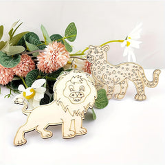 Wooden lion and leopard figurines with flowers and leaves on a white background