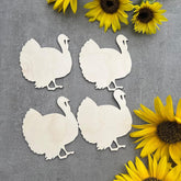 White paper cutouts of turkeys on a gray background with sunflowers.