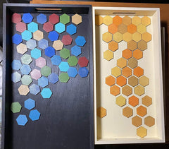 Two trays with hexagonal tile patterns in blue and orange on a wooden surface.