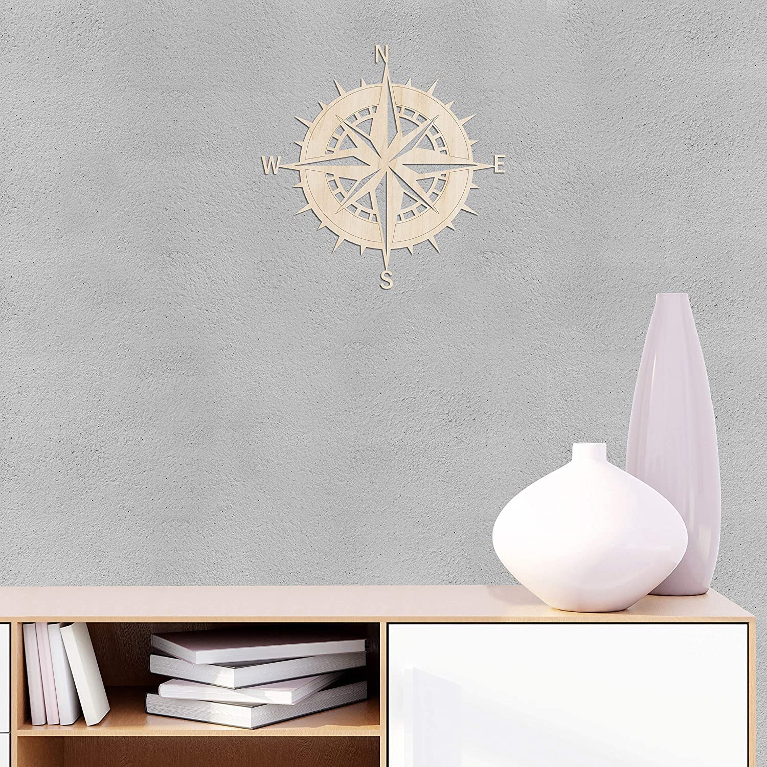 Wooden compass wall decoration on a gray wall with a shelf and vases below.