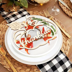 Decorative plate with 'Thankful' text and leaf design on a table setting.