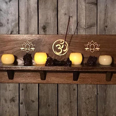 Wooden shelf with candles, incense, and decorative symbols against a wooden wall.