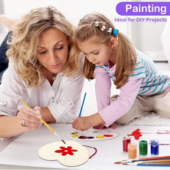 Woman and child painting together on a table with art supplies.