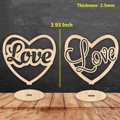 Two heart-shaped 'Love' signs with measurements on a wooden surface and dark background.