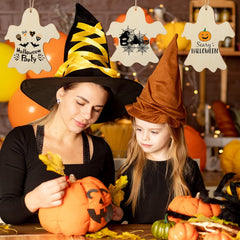 Woman and child in Halloween costumes carving pumpkins with decorations around them.