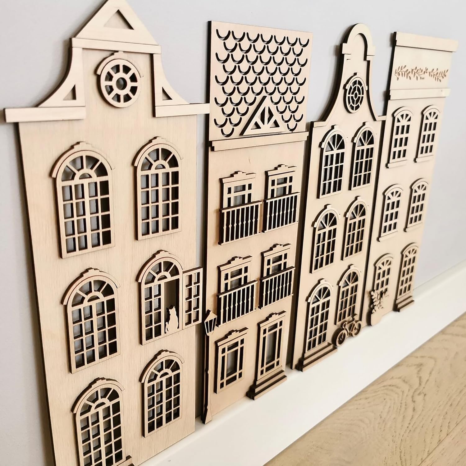 Wooden architectural models of buildings on a white surface