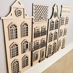 Wooden architectural models of buildings on a white surface