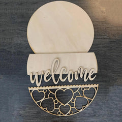 Wooden decorative sign with 'welcome' text and heart patterns on a wooden background