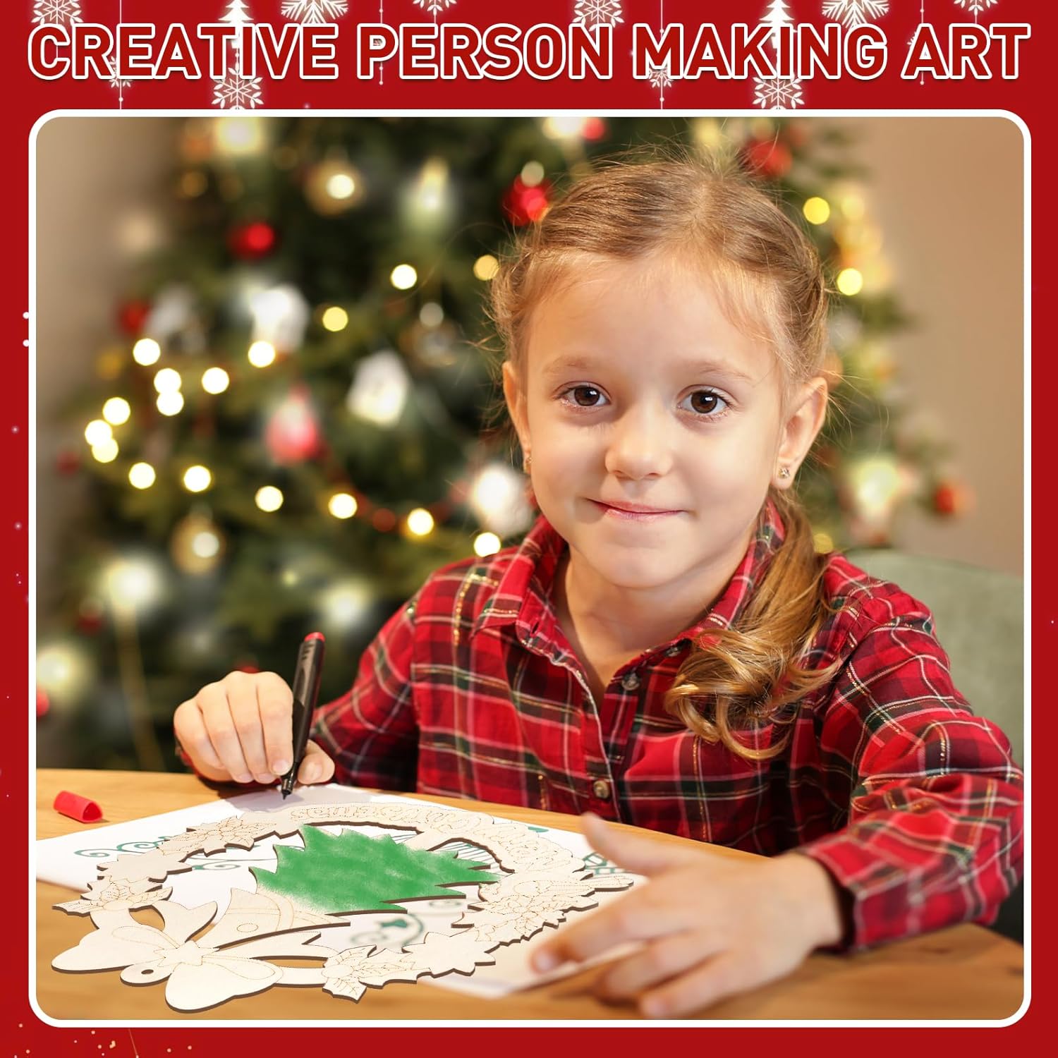 Child making art with a Christmas tree in the background