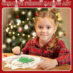 Child making art with a Christmas tree in the background