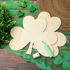 Wooden shamrock cutout with a marker on a green mat with decorative elements.