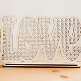 Wooden decorative sign with 'LOVE' pattern on a wooden surface