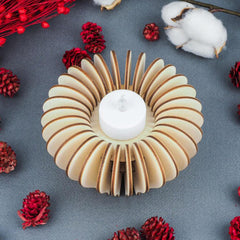 Wooden candle holder with a white candle on a gray surface with red and white decorative elements.