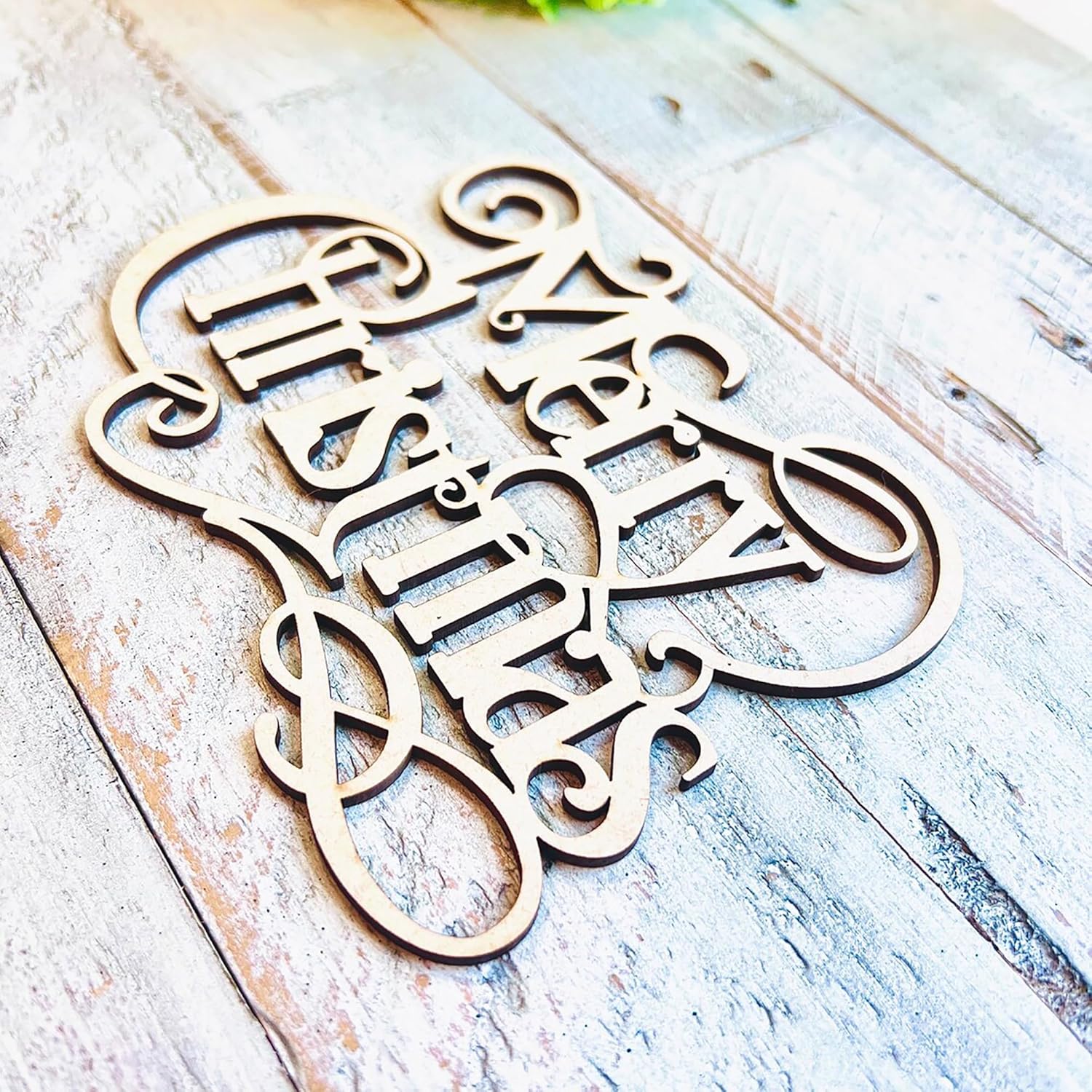 Wooden decorative sign with 'Love is All You Need' on a rustic wooden surface