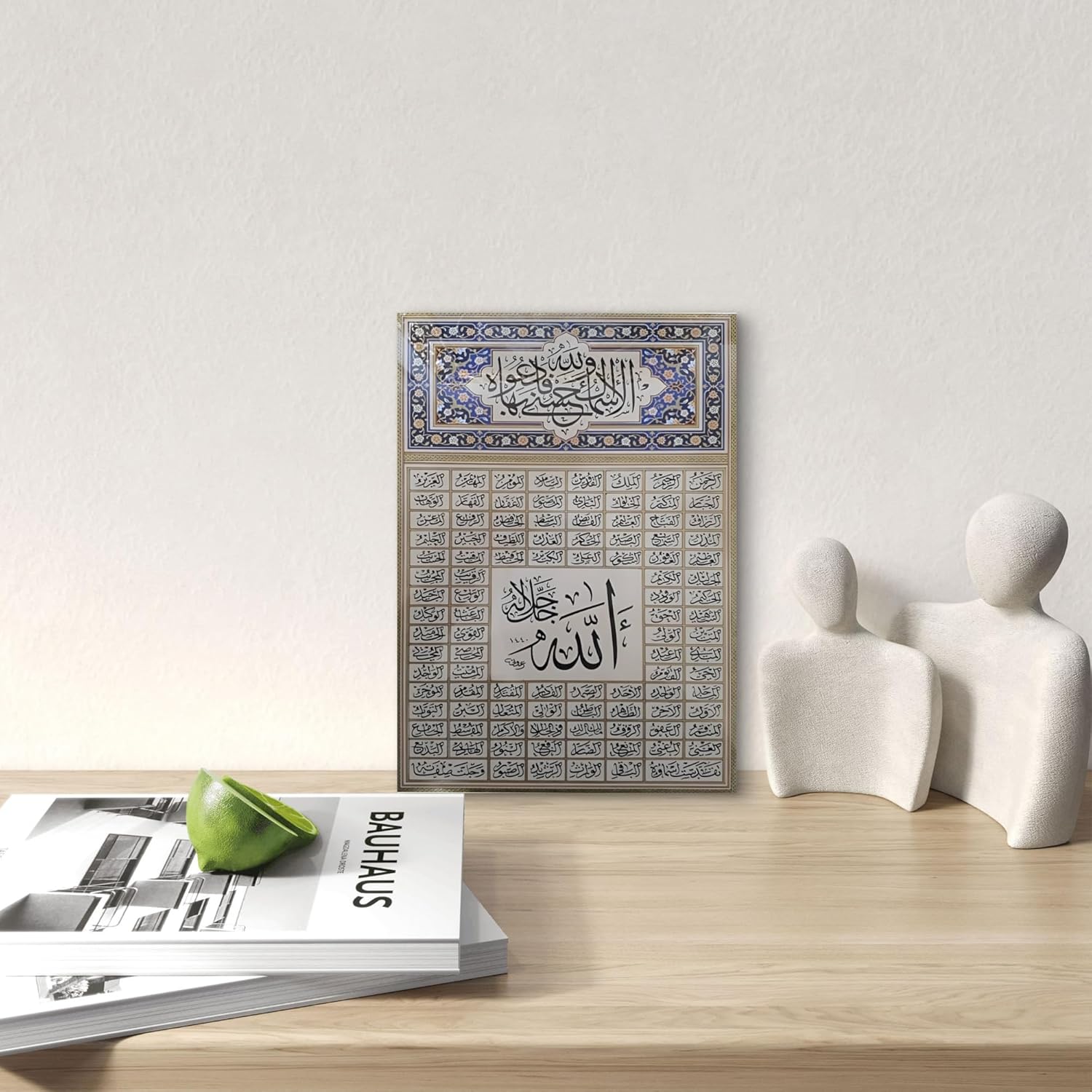 Decorative wall art with Arabic calligraphy on a wooden surface with a magazine and sculptures.
