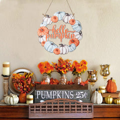 Decorative wreath with 'hello pumpkin' text and autumn-themed decor on a wall.