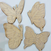Four wooden butterfly shapes on a light background