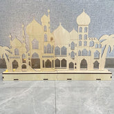 Wooden architectural model of a mosque on a gray surface with a textured wall background