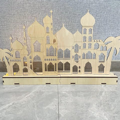 Wooden architectural model of a mosque on a gray surface with a textured wall background