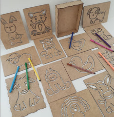 Cardboard animal templates with colored pencils on a white background