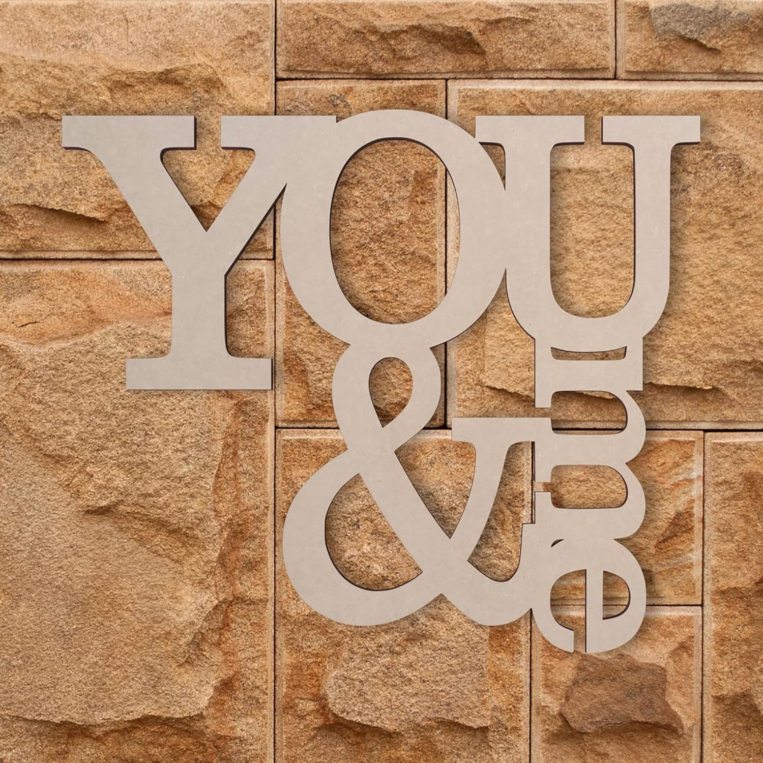 Decorative wall art with 'YOU & ME' on a stone-textured background