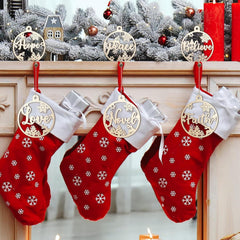 Red Christmas stockings with gold ornaments on a fireplace mantle decorated with a snowy scene.