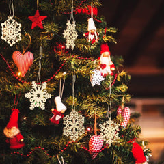 Decorative Christmas tree with various ornaments including snowflakes, hearts, and gnomes.