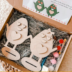 Wooden craft kit with two animal figures and paint bottles in a box